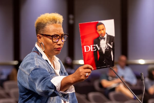 Valerie Lans-Anderson, mother of Devon Anderson, holds up a photo of her son at the City Council meeting in Atlanta on Monday, August 4, 2025. Devon Anderson was shot and killed by off-duty police officer Melvin Potter last year. (Arvin Temkar / AJC)