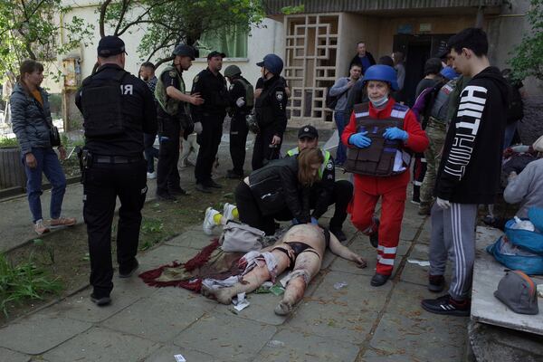 EDS NOTE: GRAPHIC CONTENT - People try to give first aid to an injured civilian at a residential building damaged by a Russian strike in Zaporizhzhia, Ukraine, Tuesday, April 22, 2025. (AP Photo/Andriy Andriyenko)