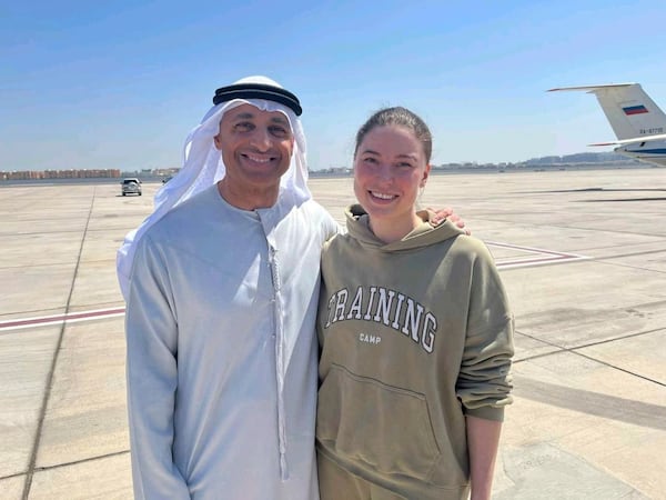 This photo released by the state-run WAM news agency shows Yousef al-Otaiba, the UAE ambassador to the U.S., left, standing next to U.S.-Russian dual national Ksenia Karelina after her release at an airport in Abu Dhabi, United Arab Emirates, Thursday, April 10, 2025. (WAM via AP)