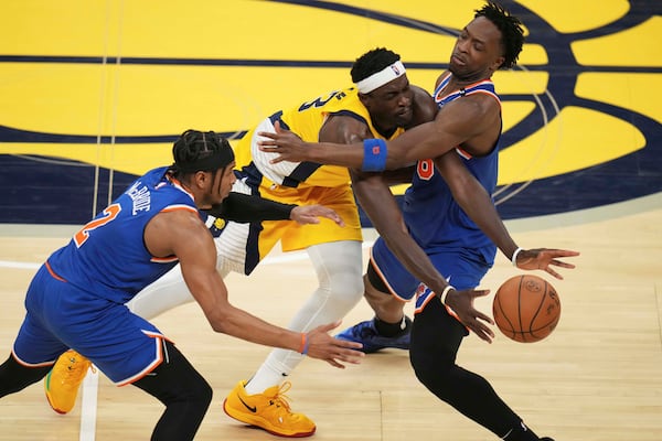Indiana Pacers forward Pascal Siakam, middle, tries to pass the ball between New York Knicks guard Miles McBride, left, and forward OG Anunoby during the second half of Game 3 of the Eastern Conference finals of the NBA basketball playoffs Sunday, May 25, 2025, in Indianapolis. (AP Photo/Jeff Roberson)