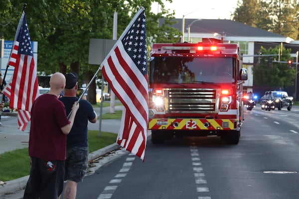 A procession from Kootenai Health headed to Spokane after a few firefighters were killed Sunday, June 29, 2025, when they were ambushed by sniper fire while responding to a blaze in a northern Idaho mountain community, in Coeur d’Alene, Idaho. (Bill Buley/Coeur D'Alene Press via AP)
