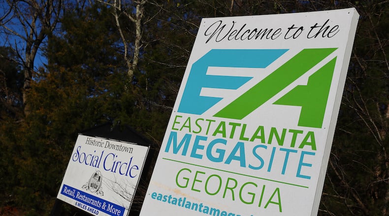 Social Circle: The East Atlanta Megasite sign marking the Rivian project site sits next to a historic downtown Social Circle sign at the Stanton Springs exit on Tuesday, Jan. 18, 2022, in Social Circle. The former chairman of the local development authority was the architect of the area's economic development while at the same time negotiated to sell his property for the Rivian project. “Curtis Compton / Curtis.Compton@ajc.com”`