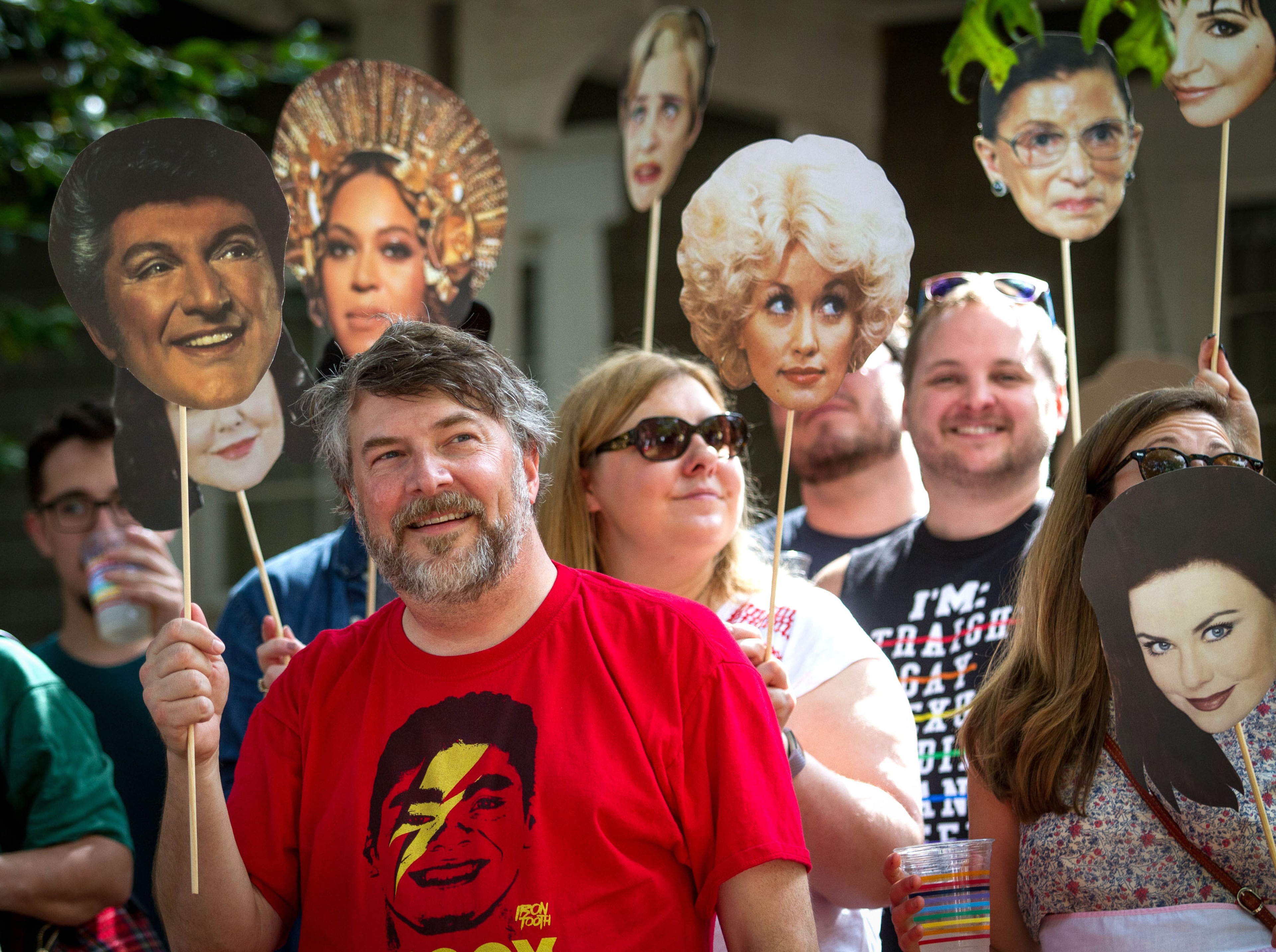 Chris Higdon and his friends hold cutouts of inspirational people as they watch the Atlanta Pride Parade head down 10th street toward Piedmont Park Sunday, October 15, 2017. STEVE SCHAEFER / SPECIAL TO THE AJC