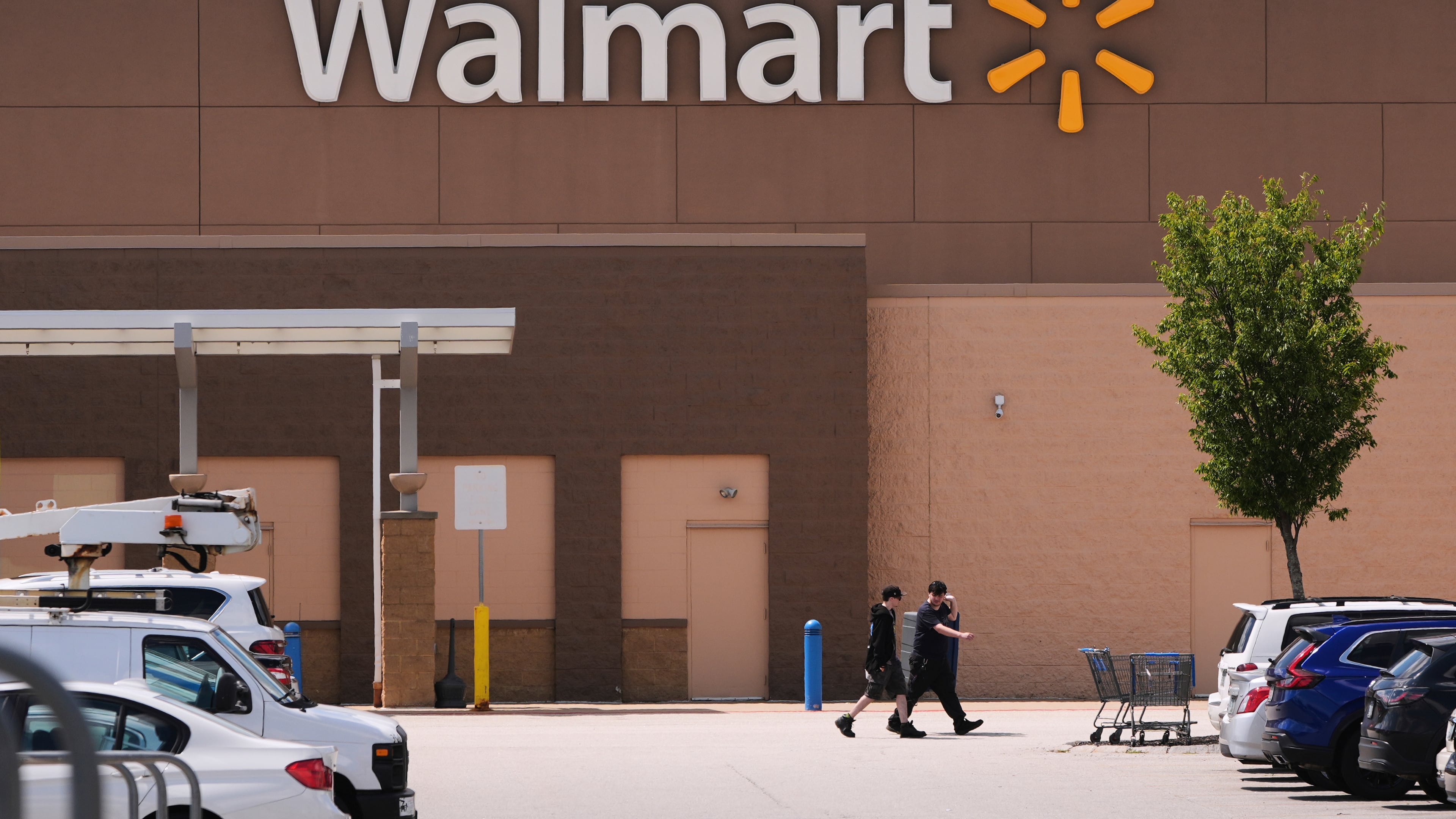 FILE - Shoppers walk from the Walmart store, Aug. 14, 2025, in Manchester, N.H. (AP Photo/Charles Krupa, File)