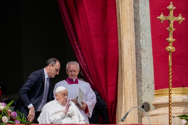 Pope Francis bestows the Urbi et Orbi (Latin for to the city and to the world) blessing from the central lodge of St. Peter's Basilica at the end of the Easter mass presided over by Cardinal Angelo Comastri in St. Peter's Square at the Vatican Sunday, April 20, 2025. (AP Photo/Gregorio Borgia)