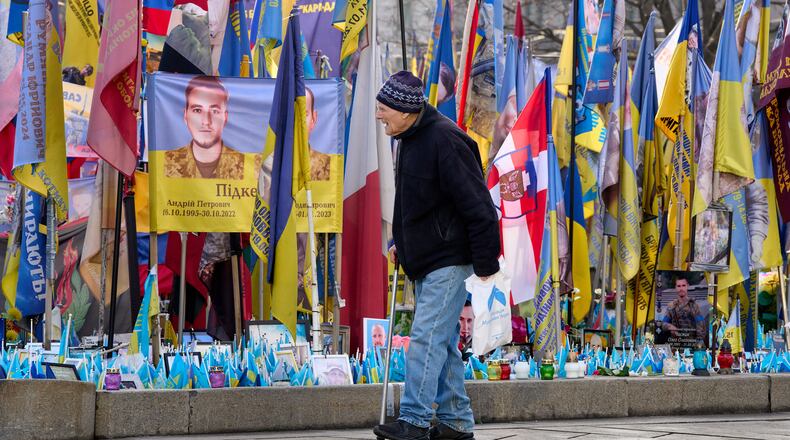 A man walks around an improvised memorial to fallen soldiers killed in the Russia-Ukraine war at Independence square in Kyiv, Ukraine, Wednesday, Dec. 10, 2025. (AP Photo/Efrem Lukatsky)