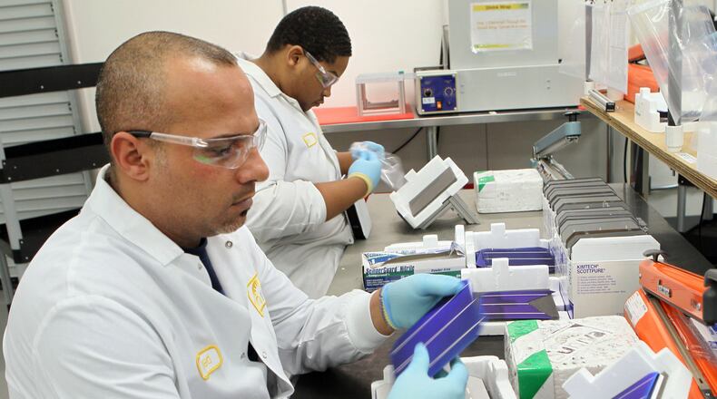 Gwinnett solar panel maker Suniva has filed bankruptcy, blaming plunging solar cell prices of dumping by Chinese manufacturers. In this file photo, Suniva workers Ahmed Alawadi (left) & Bakari Williams inspect solar cells. Photo: Phil Skinner pskinner@ajc.com