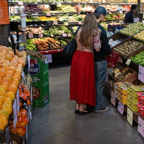 People shop in the produce section of a grocery store on Monday, May 11, 2026, in Portland, Ore. (AP Photo/Jenny Kane)