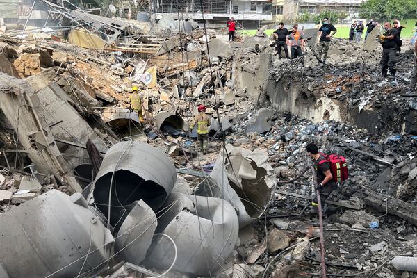 Firemen work on the site of an Israeli army strike in the suburb of Dahiye, Beirut, Friday March 28, 2025.(AP Photo/Hussein Malla)