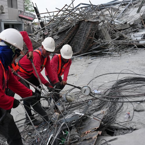 Workers cut cables during a search operation at a collapsed building where multiple people are believed to be trapped in Angeles city in Pampanga province, north of Manila, Philippines, Monday, May 25, 2026. (AP Photo/Aaron Favila)