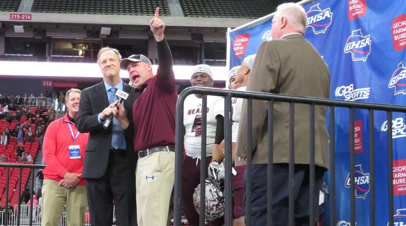 Heard County Braves coach Tim Barron and his players stand on the podium after the Class AA state championship game following their 27-6 win over the Rockmart Yellow Jackets on Wednesday, Dec. 12, 2018 at Mercedes-Benz Stadium. (Adam Krohn/special)
