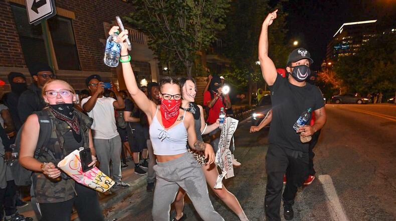 Small groups of people roam the streets  after curfew Saturday, some vandalizing property, as protests began for a second day.  Protests over the death of George Floyd in Minneapolis police custody spread around the United States on Saturday, as his case renewed anger about others involving African Americans, police and race relations.     Hyosub Shin / hyosub.shin@ajc.com