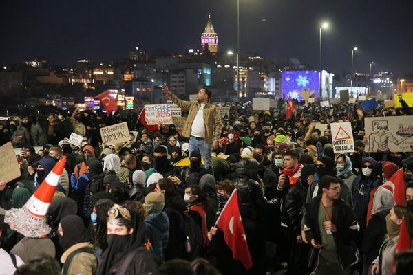 University students march across Galata bridge during a protest after Istanbul's Mayor Ekrem Imamoglu was arrested and sent to prison, in Istanbul, Turkey, Monday, March 24, 2025. Boards read in Turkish: "Be careful, bee may sting", "Our diploma is upright". (AP Photo/Huseyin Aldemir)