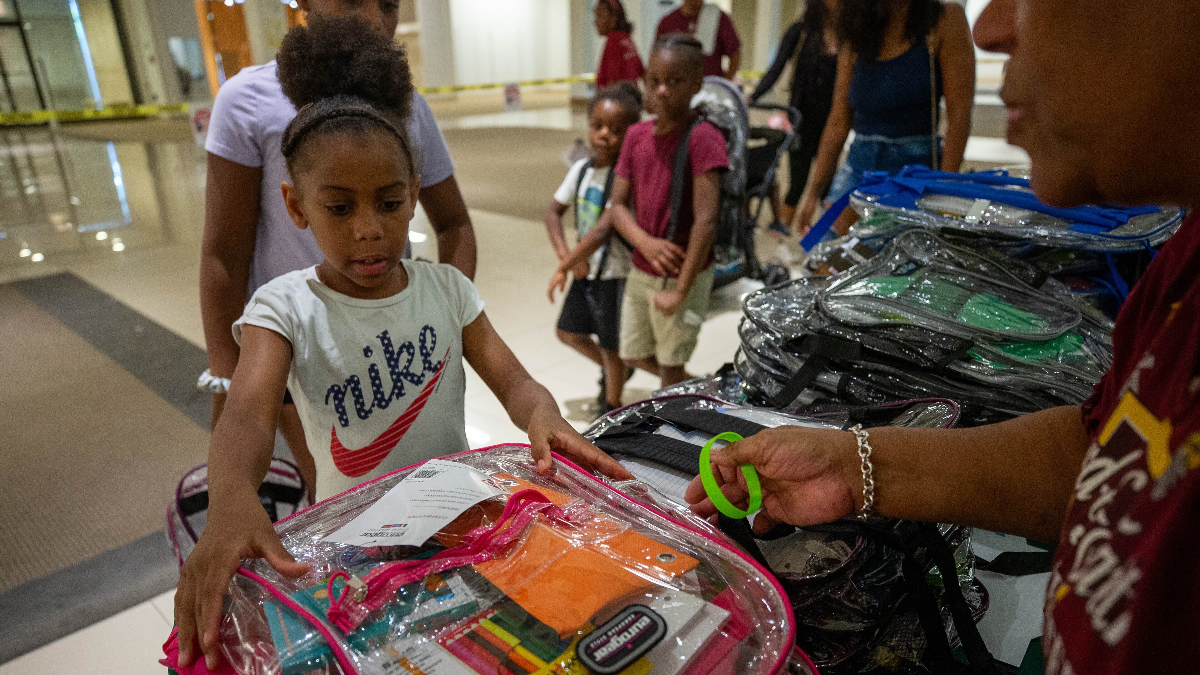 Makayla Smith receives a free school supply kit and clear backpack at the 20th annual Back-to-School Bash at Greenbriar Mall in Atlanta on Saturday, July 22, 2023. (Katelyn Myrick/AJC)