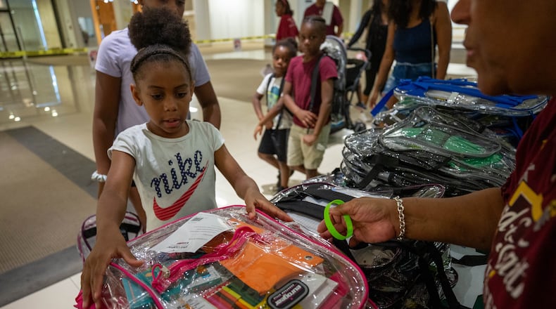 Makayla Smith receives a free school supply kit and clear backpack at the 20th annual Back-to-School Bash at Greenbriar Mall in Atlanta on Saturday, July 22, 2023. (Katelyn Myrick/AJC)
