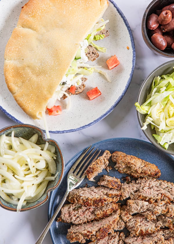 Quick Lamb Gyros can be served like a taco bar. Bring out the meat, onions, pita, sauce and other toppings, and let everyone build their gyros just as they’d like. (Aaliyah Man for the AJC/food styling by Kate Itrich-Williams)