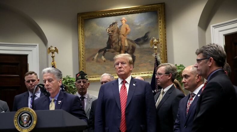 President Donald Trump listens as Frank Larkin, left, a retired Navy Seal, speaks during an executive order signing ceremony at the White House on the National Roadmap to Empower Veterans and End Veteran Suicide March 5, 2019 in Washington, D.C. Larkin’s son Ryan, also a Navy Seal, took his own life due to the effects of a traumatic brain injury sustained during his military career. Win McNamee/Getty Images