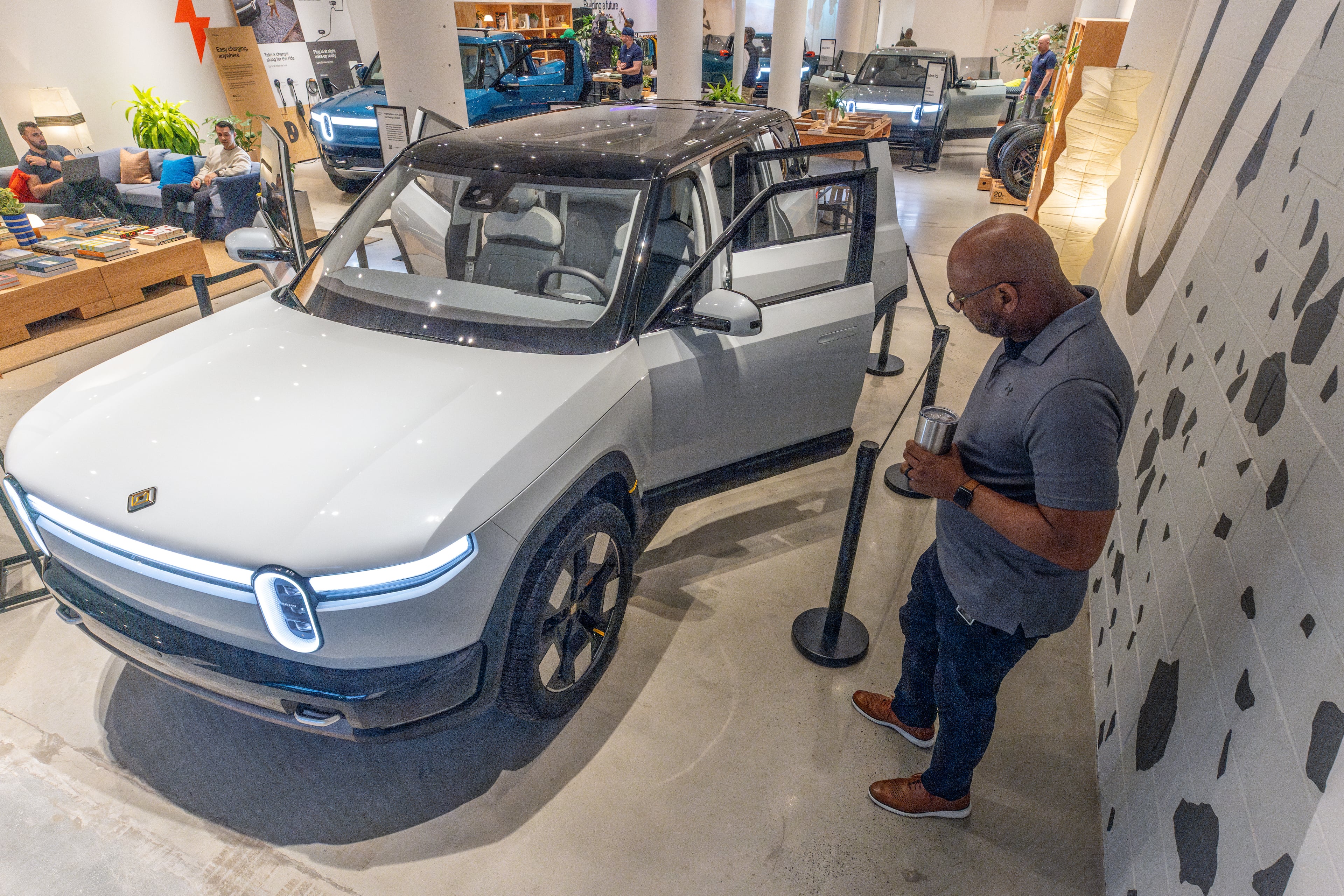 Rivian employee Russ Mooney looks over the new R2 prototype that will eventually be made in Georgia at the Ponce City Market in Atlanta on April 27, 2024. (Steve Schaefer/AJC)