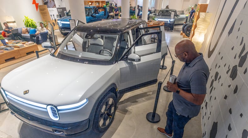 At Ponce City Market in Atlanta on April 27, 2024, Rivian employee Russ Mooney looks over the new R2 prototype that will eventually be made in Georgia. (Steve Schaefer / AJC)