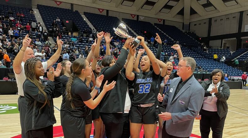 Mount Paran Christian head coach Stephanie Dunn, senior Ciara Alexander (32) and teammates celebrate with the trophy after their 59-52 victory over Josey in the Class 2A girls basketball championship game at the Macon Coliseum on March 7, 2024.