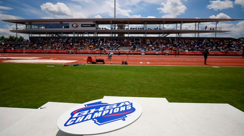 A GHSA logo is seen on the athletes’ podium during the boys 1,600 meters at the Class A Division II GHSA track and field state championships Monday, May 11, 2026, at Spec Towns Track at the University of Georgia in Athens. (Miguel Martinez/AJC)