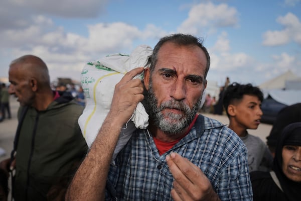 Palestinians carry bags filled with food and humanitarian aid provided by the Gaza Humanitarian Foundation, a U.S.-backed organization approved by Israel, in Khan Younis, southern Gaza Strip, on Tuesday, June 3, 2025. (AP Photo/Abdel Kareem Hana)