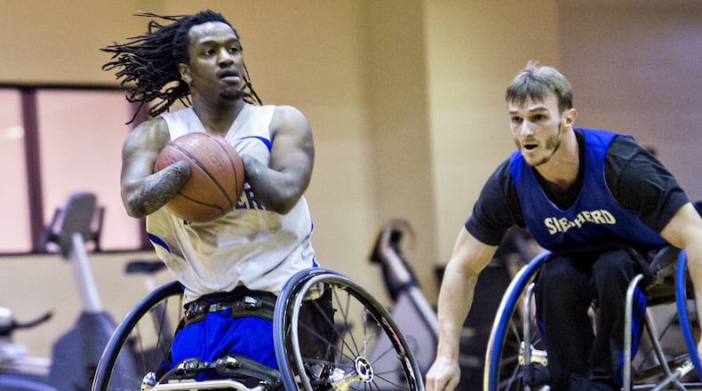 James Adams (left) dribbles the ball down the court as he is chased by Samir Jusupovic during basketball practice at the Shepherd Center in Atlanta. Adams is one of the top players for the Shepherd Center wheelchair basketball team, averaging nearly 12 points a game. He does this without hands.