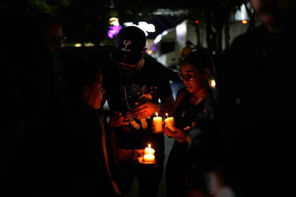 People light candles at a makeshift memorial outside the Jet Set nightclub, in memory of the more than 200 people who died when its roof collapsed, in Santo Domingo, Dominican Republic, Friday, April 11, 2025. (AP Photo/Matias Delacroix)