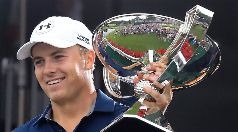 Jordan Spieth hoists the FedEx Cup after his four-stroke Tour Championship victory. (Curtis Compton / ccompton@ajc.com)