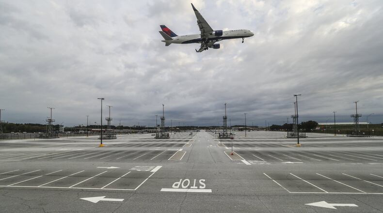 A plane descends Tuesday, March 31, 2020 over Hartsfield-Jackson International Airport, where flights have fallen off drastically since the coronavirus pandemic. JOHN SPINK/JSPINK@AJC.COM