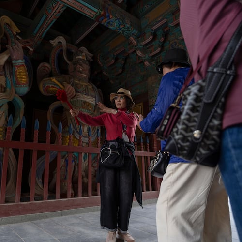 A guide briefs visitors at the Bulguksa Temple where preparations are underway ahead of events for attendees of the Asia-Pacific Economic Cooperation (APEC) summits in Gyeongju, South Korea, Thursday, Oct. 30, 2025. (AP Photo/Ng Han Guan)