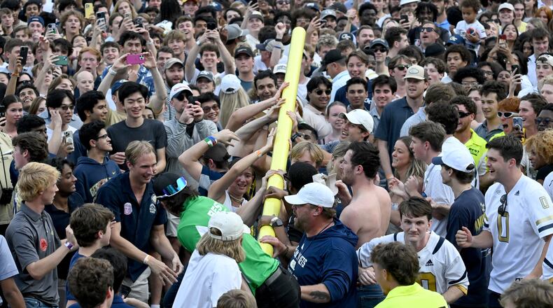 Georgia Tech fans try to lift a goalpost after an NCAA college football game against Miami at Georgia Tech's Bobby Dodd Stadium, Saturday, November 9, 2024, in Atlanta. Georgia Tech won 28-23 over Miami. (Hyosub Shin / AJC)