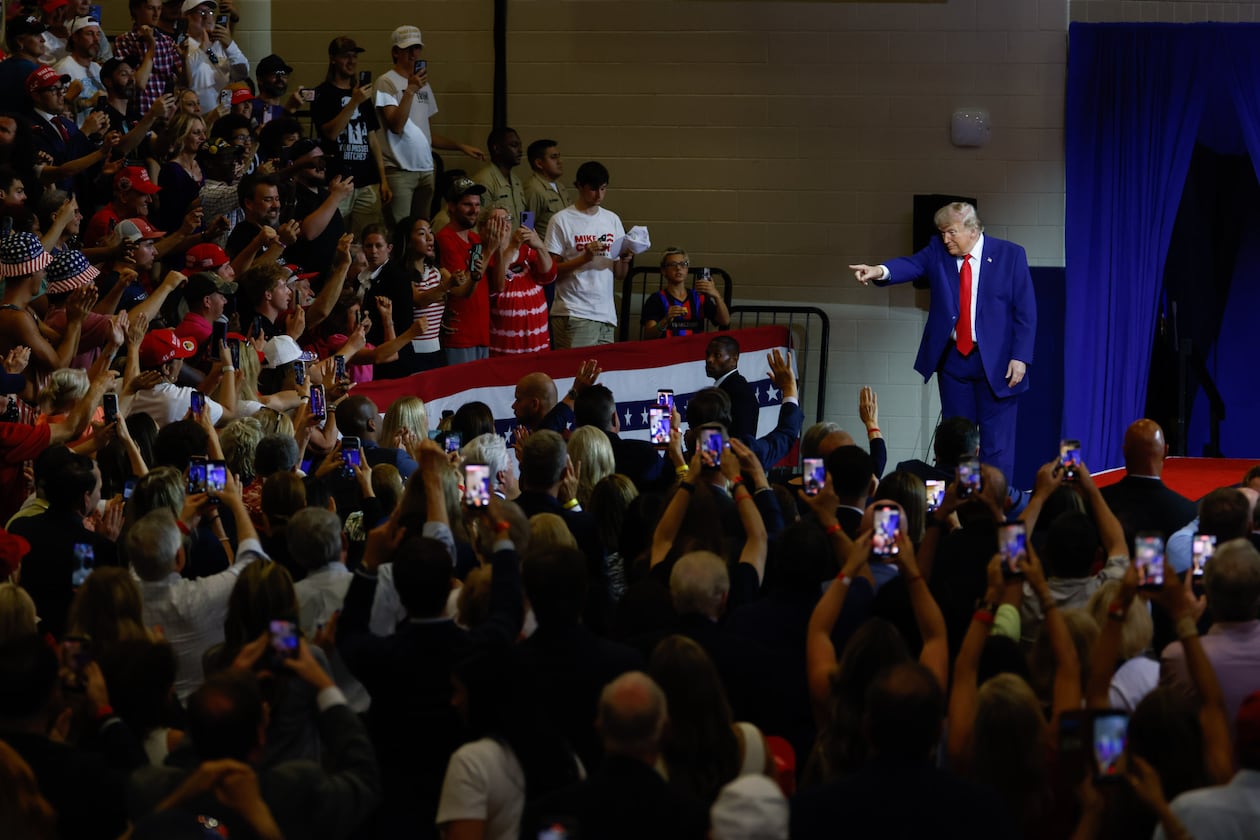 President Donald Trump points to the crowd after speaking at Wheeler High School in Marietta on Wednesday. (Arvin Temkar/AJC)