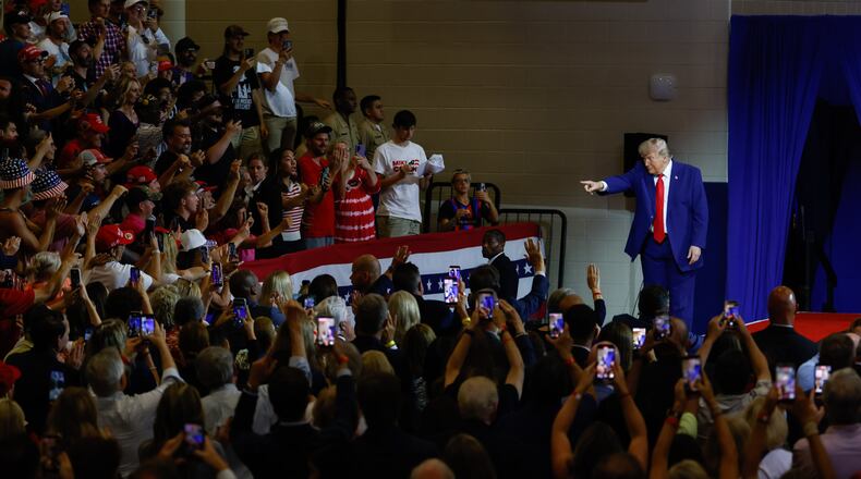 President Donald Trump points to the crowd after speaking at Wheeler High School in Marietta on Wednesday. (Arvin Temkar/AJC)