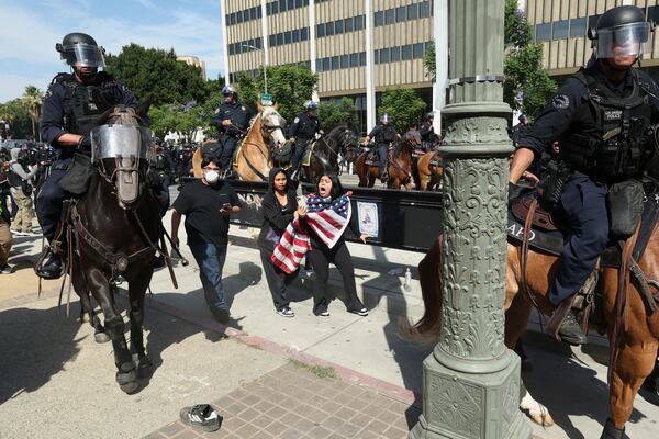 Law enforcement on horseback disperse demonstrators during a protest Saturday, June 14, 2025, in Los Angeles. (AP Photo/Ethan Swope)
