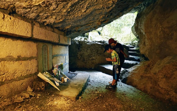 People pray for victims inside a cave in Itoman, Okinawa prefecture, southern Japan Monday, June 23, 2025 as Japan marked the 80th anniversary of the end of the Battle of Okinawa. (Mizuki Sakai/Kyodo News via AP)