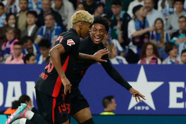 Barcelona's Lamine Yamal, left, celebrates with his teammate Alejandro Balde after scoring his side's opening goal during a Spanish La Liga soccer match between Barcelona and Espanyol at Lluis Companys Olympic Stadium in Barcelona, Spain, Thursday, May 15, 2025. (AP Photo/Joan Monfort)