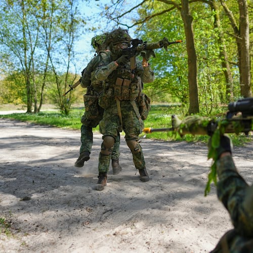 Members of the 10th Infantry Battalion Guard Security Corps National Reserve secure the crossing of a road during a weekend exercise to hone their military skills as the Netherlands beefs up its military with new recruits and volunteer reservists in Havelte, Netherlands, Saturday, April 25, 2026. (AP Photo/Peter Dejong)