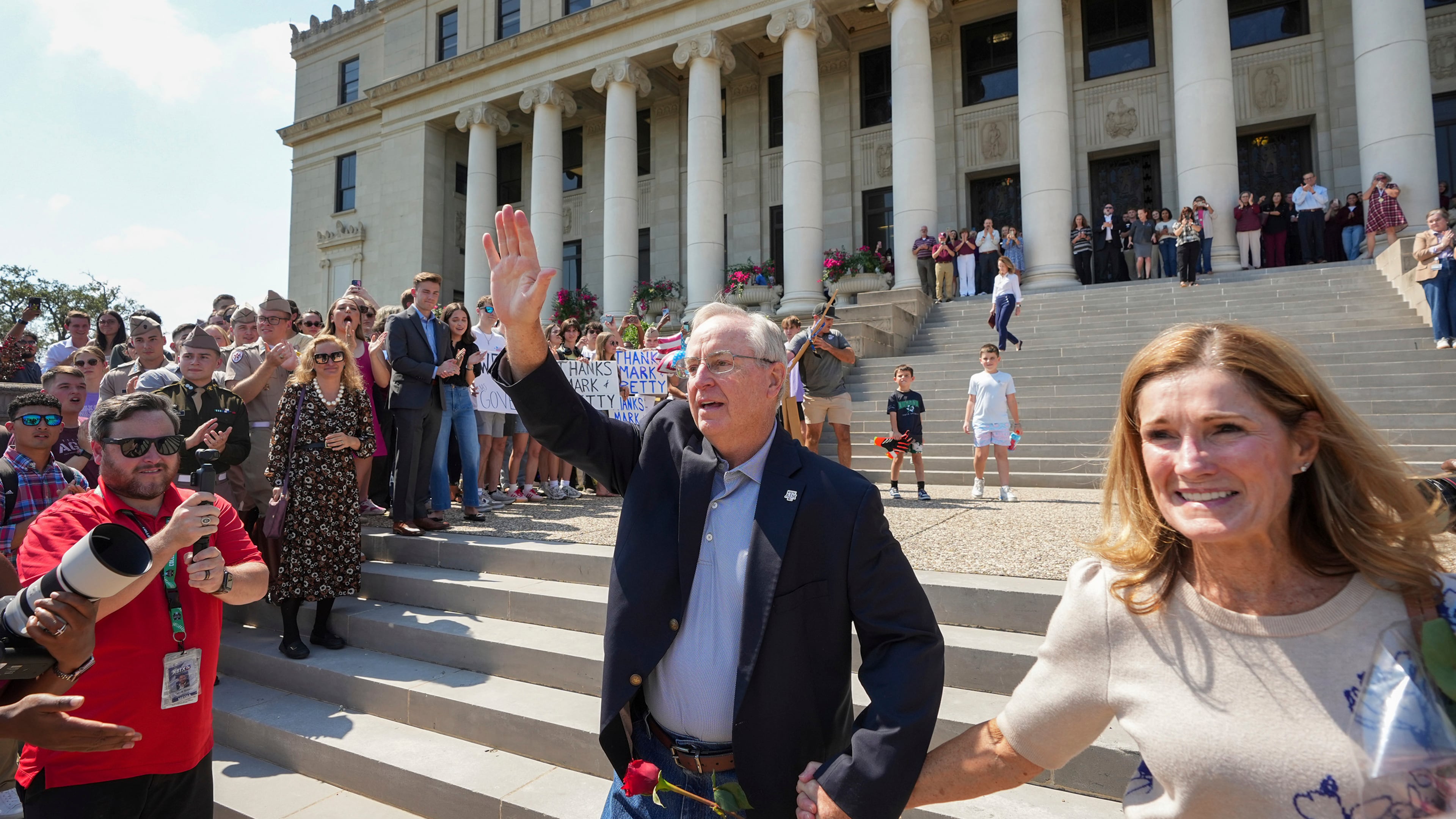 Texas A&M University President Mark Welsh, accompanied by his wife, Betty, exits the administration building after resigning in College Station, Texas, on Friday, Sept. 19, 2025. (Jay Janner/Austin American-Statesman via AP)