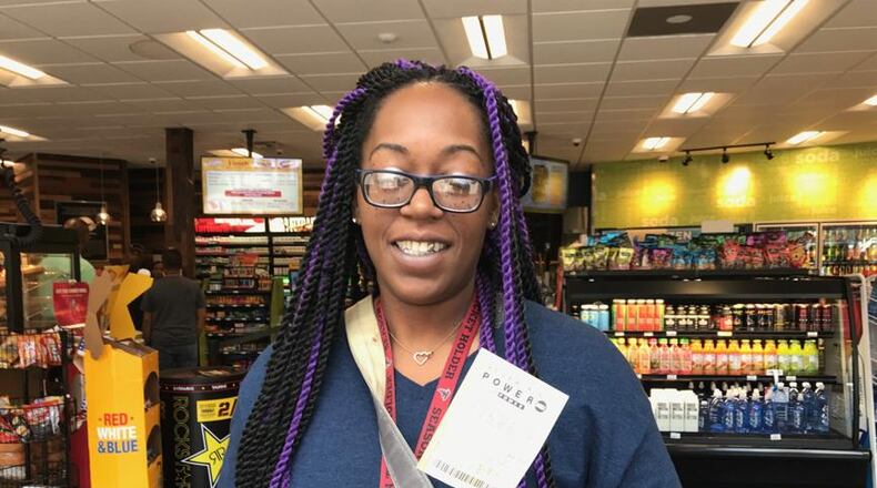 Kennesaw resident Audria Burge shows the Powerball ticket she bought Saturday at the Exxon station in Dunwoody. Saturday's jackpot is $337 million. ERIC STIRGUS / ESTIRGUS@AJC.COM