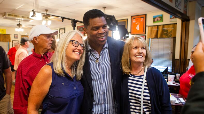 Herschel Walker (middle) takes a photo with Jan Smythe (right) and another woman (left), during a meet and greet event on Wednesday, July 27, 2022, at Longstreet Cafe in Gainesville, Georgia. Fox & Friends broadcasted live from the restaurant during which co-host Brian Kilmeade interviewed Walker. CHRISTINA MATACOTTA FOR THE ATLANTA JOURNAL-CONSTITUTION.