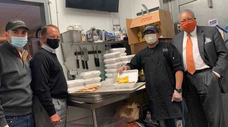 Fulton County Commission Chairman Robb Pitts (far right) and County Manager Dick Anderson (second from the left) pose with staff of Nowak’s, which is one of six restaurants that has a contract with the county to provide meals for children in extended-stay motels. (Photo provided by Dick Anderson)