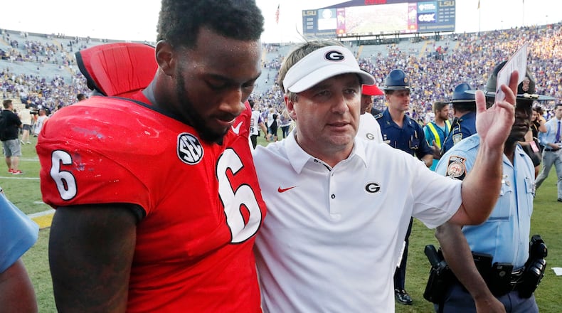 Georgia coach Kirby Smart walks off the field with linebacker Natrez Patrick (6) after the loss. BOB ANDRES / BANDRES@AJC.COM