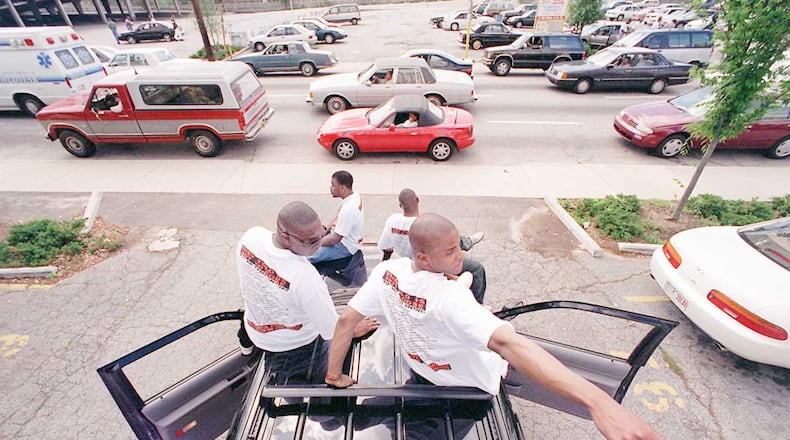 James Tate 18 right of Detroit points out some activity behind him to his friend Modd Washington 21 as the group plays music and watches the Freaknik traffic creep by on Spring Street near The Varsity restaurant on Friday Also on the truck in front are Demetrius Danforth 24 left and Meadstro Washington 24 All are from Detroit