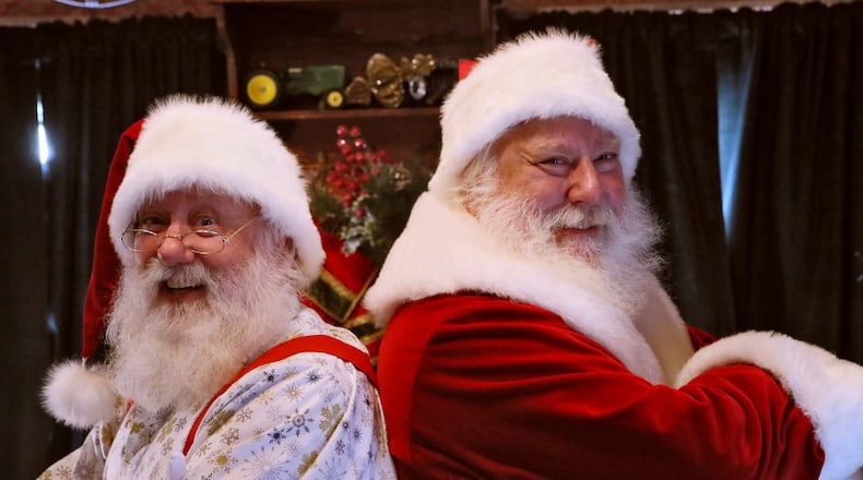 Santa Pete (right) talks shop with his brother, Santa Rick, at the Santa House at Avalon in Alpharetta. Santa Pete has several decades under his ample belt playing Santa in parades, malls and holiday gatherings. Santa Pete, who works out of Atlantic Station, followed in the black boots of his dad, who also donned the red suit as Santa. This year, his older brother, Rick, is donning a white beard and playing Santa at the new Avalon shopping development. BOB ANDRES / BANDRES@AJC.COM