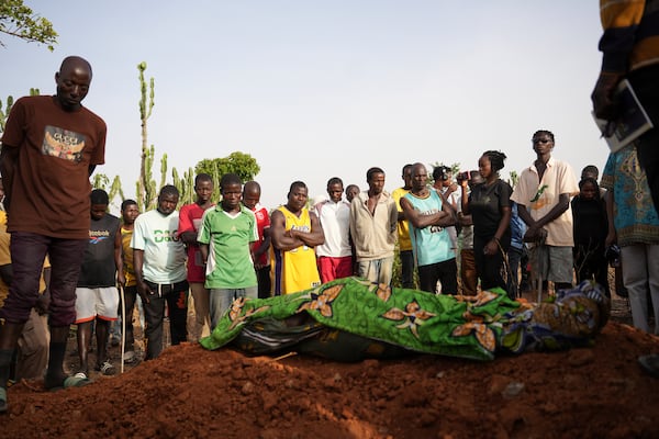 People attend the funeral of a man that was killed following an attack by gunmen in the Zike farming community in north-central Nigeria, Tuesday, April 15, 2025. (AP Photo/Samson Omale)