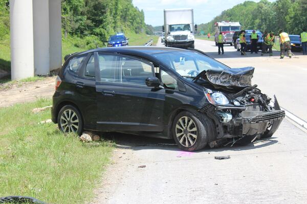 A black Honda Fit was struck by one of the fallen logs.