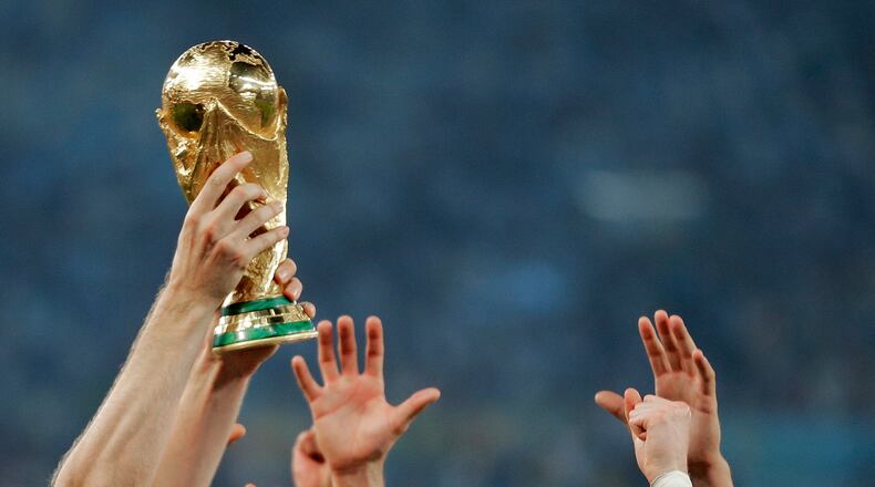 FILE - German players reach out to touch the trophy after the World Cup final soccer match between Germany and Argentina, in Rio de Janeiro, Brasil, July 13, 2014. (AP Photo/Matthias Schrader, File)