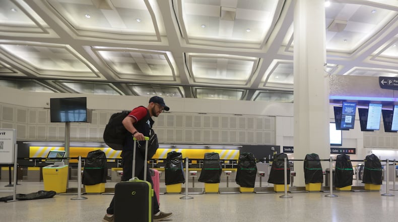A traveler walks past covered Spirit Airlines kiosks, Saturday, May 2, 2026, at George Bush Intercontinental Airport, in Houston. (AP Photo/Lekan Oyekanmi)