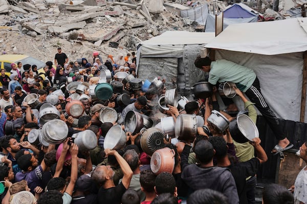 Palestinians struggle to get donated food at a community kitchen in Jabalia, northern Gaza Strip, Thursday, May 15, 2025. (AP Photo/Jehad Alshrafi)